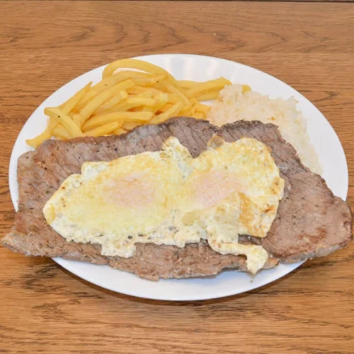 Palomilla Steak & Eggs - Grilled palomilla steak served with eggs, rice, and beans.